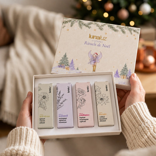 Coffret Rituels de Noël LunaLuz ouvert, tenu à deux mains, avec ses 4 roll-ons